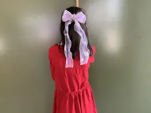 Detailansicht der lila Organza Kinder Haarschleife mit Bändern und Schneeflocken Design.