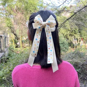 Children creamy white polka dot bow hair clip with cute streamers for lovely girls styling daily wear.