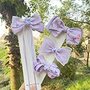 Nahaufnahme von lila Chiffon Cartoon Druck Schleife Haarklammern auf Displaykarte draußen.