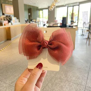 Large pearlescent gauze bow hair clip detail view, elegant children hair accessory.