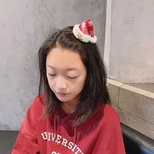 Cute mini Christmas hat hair clip for girls, festive red hair accessory for holiday parties.