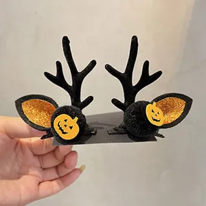 Nahaufnahme Detail von Halloween Hirschgeweih Haarspangen mit Kürbis und Fledermaus Ohr.