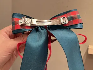 Vue détaillée de l'arrière de la pince à cheveux nœud de Noël et rubans de satin.