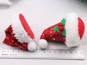 Close-up detail of mini red sequined Christmas hat hair accessories with fluffy white trim.