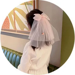 Detailed view of children's pink mesh bow hair clip, showing the elegant veil and cute design.