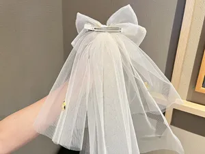 Detail view of the children white mesh bow hair clip with veil, showing craftsmanship.