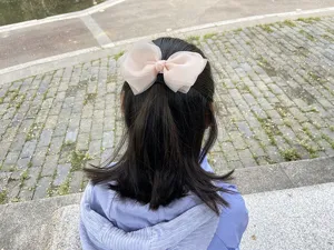 Detailed outdoor close-up view of the sweet pink organza mesh bow hair clip product.
