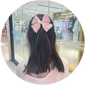 Charming pink sequin bow hair clip detail, sparkling cute accessory for little girls daily wear.