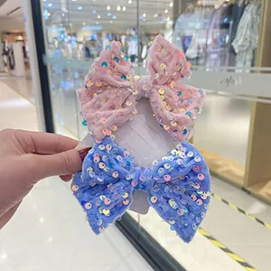 Close-up details of sparkling velvet sequin bow hair clips, lovely decoration for kids.