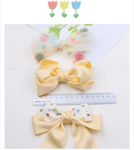Süße Kinder Haarschleife Detailansicht mit bunten Punkten, Mesh und weichem Satinmaterial.