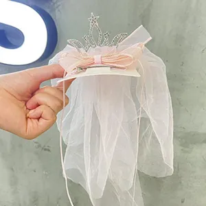 Detailed view of cute baby girl pink crown hair clip with elegant tulle veil and sparkling rhinestones.