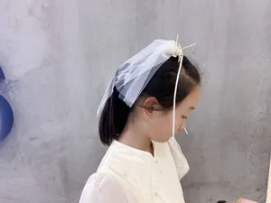Detailed shot of cute white veil hair clip with mesh and ribbon for lovely girls and kids.