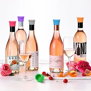 Close-up detail of colorful silicone wine bottle stoppers sealing glass bottles with roses and glasses.