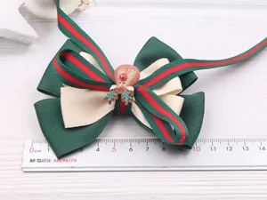 Pince à cheveux nœud vert de Noël avec sangle rayée rouge et joli détail de renne.