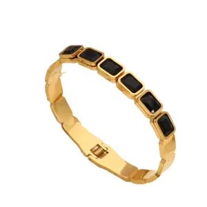 Edler Edelstahl Gold Armreif mit schwarzen rechteckigen Zirkonia Steinen, geometrisches Design.