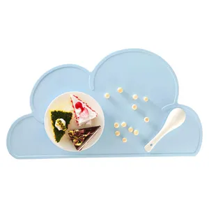 Detail view of light blue silicone cloud placemat, showing fine texture and mealtime scene details.