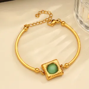 Gouden roestvrijstalen armband met vierkante hanger en groene kattenoogsteen.