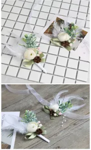 Detail view of elegant wedding boutonniere with white flower, feathers, and green leaves.