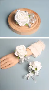 Elegant white artificial rose wedding wrist corsage and boutonniere set with silver ribbon.