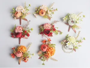Detailed view of European wedding boutonnieres and pearl wrist corsages for bridal party.