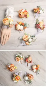 Detailed view of orange forest-style artificial wrist flowers and matching wedding corsages.