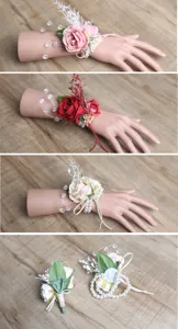 Dettagli di corsage da polso con rose artificiali, perle e cristalli per matrimoni.