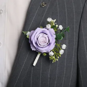 Vista detallada de botonera de rosa morada artificial con brotes blancos para traje de boda.