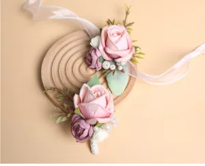 Detailopname van kunstmatige roze trouwcorsage met delicate linten en parelaccenten.