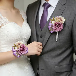 Primo piano dettagliato di un set di fiori da polso e boutonnière di rose artificiali.