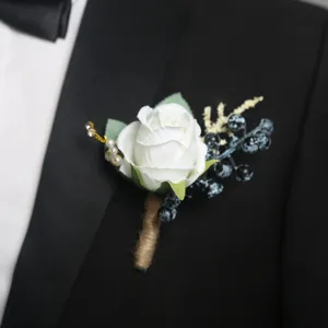 Elegante bottoniera di rose bianche con bacche blu e stelo in juta, ideale per matrimoni.
