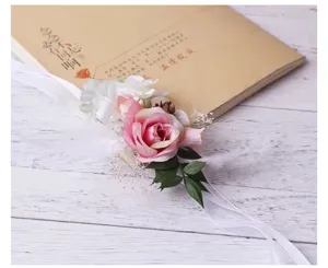Pink rose wrist flower wedding corsage with white ribbon and pine cone rustic style