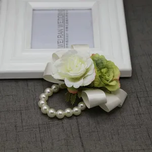 Dettaglio in primo piano del corsage da polso di rosa artificiale con bracciale di perle.