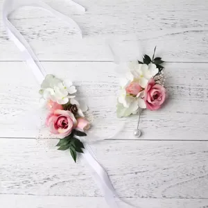 Romantic wedding pink rose wrist flower and boutonniere set with white ribbon and pinecones.