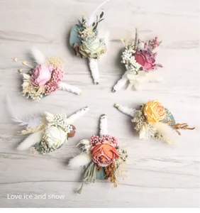 Set of handmade wedding boutonnieres with dried flowers and artificial roses for groom suit decor.