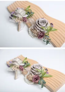 Purple artificial flower wedding wrist corsage and boutonniere set, elegant floral design detail.