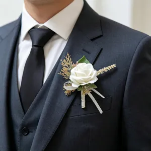 Detail shot of a white simulated rose boutonnière with gold grass for wedding suit.