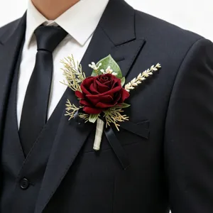 Detailed view of the dark red rose boutonniere worn on a black suit lapel for wedding.