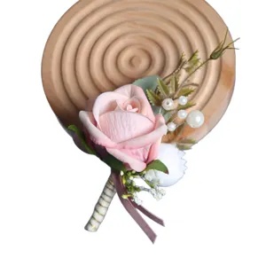 Élégante boutonnière de rose rose artificielle avec perles pour mariage occidental.