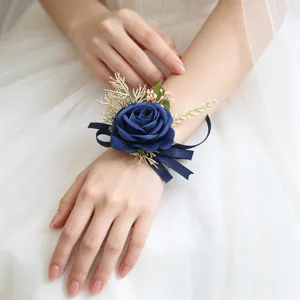 Close-up detail view of the elegant blue rose wrist corsage with ribbons and gold leaves.
