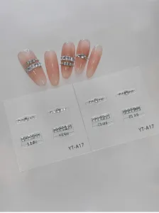 Primer plano detallado de pegatinas de uñas con cadena de pedrería cuadrada y diseño brillante.