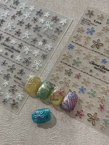 Detailed view of 3D floral nail art stickers and finished nail tips with elegant designs.