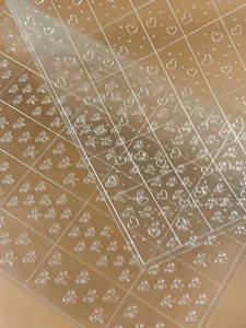 Pegatinas de uñas en relieve 3D transparentes con lazos y corazones bonitos, primer plano detallado.