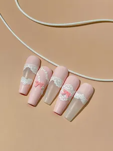 Detail view of pink press-on nails featuring elegant white lace relief and cute bows.