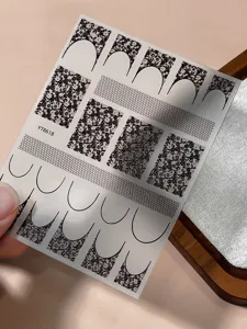 Close-up of vintage French lace nail stickers featuring elegant floral patterns.