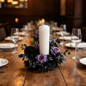 Close-up of gothic dark purple rose and black eucalyptus candle ring centerpiece detail scene.