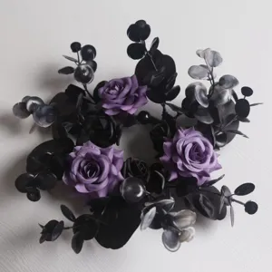 Dark purple rose candle ring with artificial black eucalyptus leaves for elegant wedding table decor.