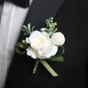 Élégante boutonnière de rose blanche avec ruban vert pour costume de mariage.