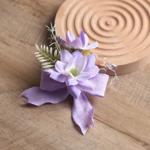 Detailansicht des lilafarbenen Stoffblumenkorsages mit eleganten Bändern und Perlen für Hochzeiten.