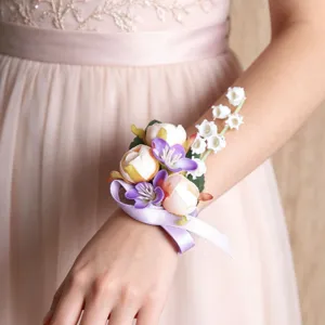 Nahaufnahme eines floralen Handgelenkkorsages in zarten Rosa- und Lilatönen für Hochzeiten.