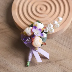 Nahaufnahme des handgemachten künstlichen Blumen-Ansteckers in violett-rosa Morandi-Tönen.